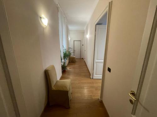 a hallway with a chair and a white door at Paradise Rooms - Brignole Station in Genova