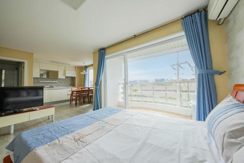 una camera con un letto e una grande finestra di Mega Resort a Jeju