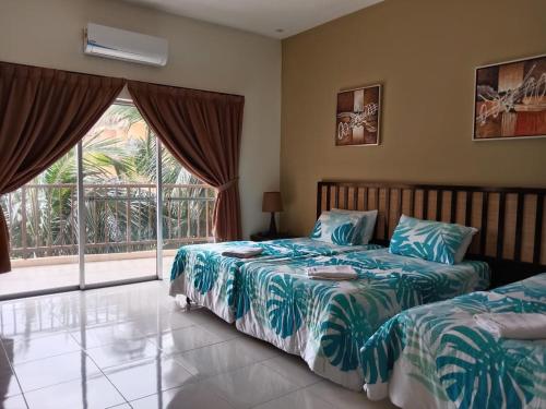 a bedroom with two beds and a large window at Gold Coast Morib Resort in Banting