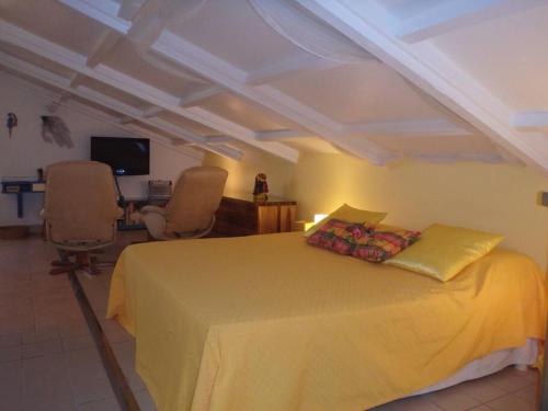 a bedroom with a yellow bed and two chairs at Charmant et spacieux studio à 50m de la plage in Le Diamant