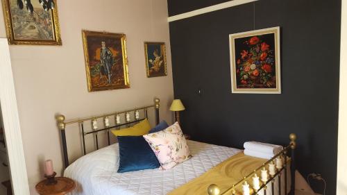 een kleine slaapkamer met een bed en schilderijen aan de muur bij Montagu Manor in Montagu
