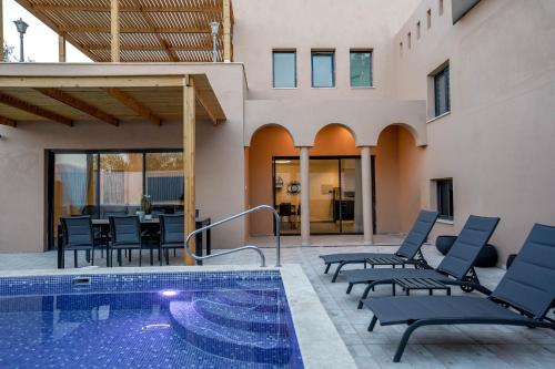 um pátio com cadeiras e uma piscina em וילה רוני בריכה מחוממת Villa Roni Heated pool em Eilat