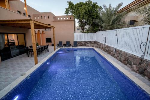 uma piscina num quintal com uma casa em וילה רוני בריכה מחוממת Villa Roni Heated pool em Eilat