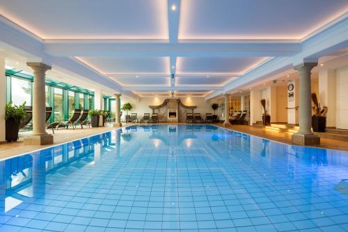 a swimming pool in a large building with a swimming pool at Hotel & Restaurant Wastlwirt in Sankt Michael im Lungau