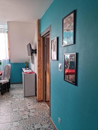 a hallway with a blue wall with pictures on it at Ostoja Karkonoska in Podgórzyn