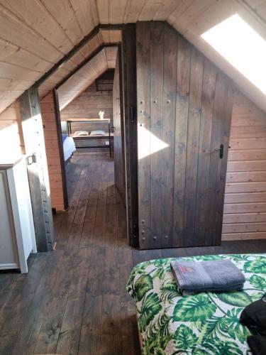 a room with a bed and a wooden wall at Ostoja Karkonoska in Podgórzyn
