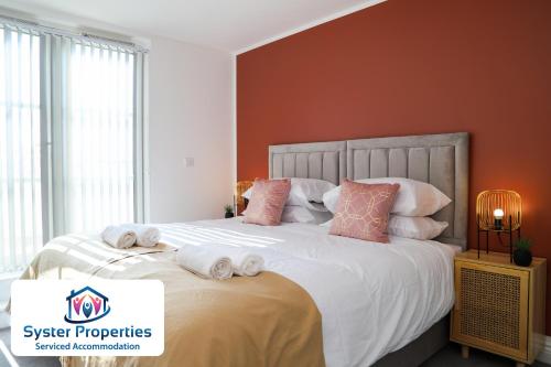 a bedroom with a large bed with towels on it at Syster Properties Leicester large home for Contractors, Families , Groups in Leicester