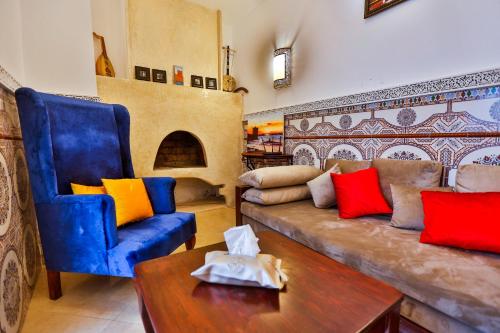 uma sala de estar com um sofá, uma cadeira e uma mesa em Riad Alech em Essaouira