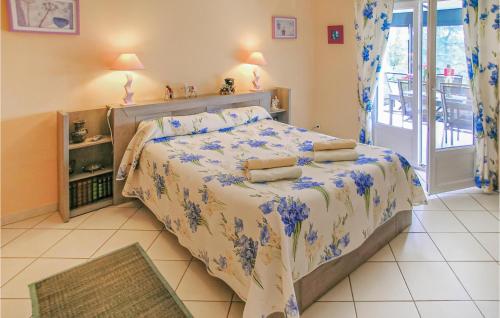 Savignac-les-ÉglisesにあるAmazing Home In Savignac Les Eglises With 3 Bedrooms, Wifi And Outdoor Swimming Poolのベッドルーム1室(青い花のベッド1台付)