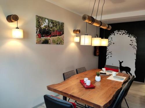 een eettafel met stoelen en een kat aan de muur bij Ferienhaus Blaue Blume mit 11 kW Ladestation, Kamin, Terrasse, eingezäuntem Garten, Sauna, WLAN, Netflix, 2 Hunde willkommen! in Güntersberge
