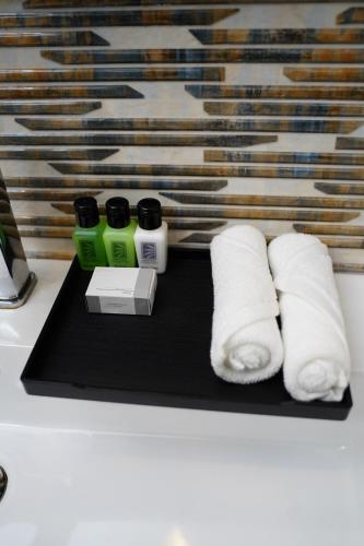 - un plateau noir avec 3 rouleaux de papier toilette sur un comptoir dans l'établissement Village Hotel Northern Point, à Point Pedro