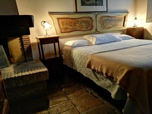 Un dormitorio con una cama grande y una lámpara en una mesa. en BeB LE CASE ROSSE, en Verucchio