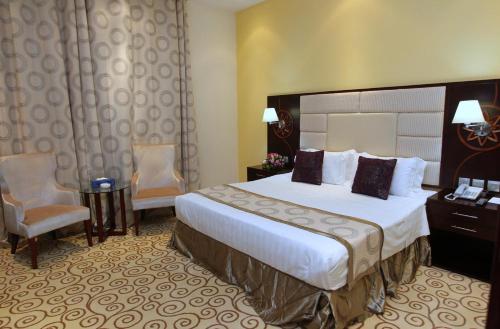 a hotel room with a bed and a desk and chairs at Palm Inn Hotel Doha in Doha