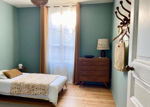 a bedroom with a bed and a window and a dresser at GÎTE DE LA MUSARDE in Villers-sur-Mer