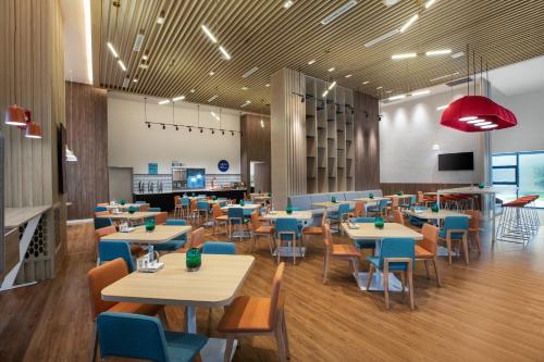 une salle à manger avec des tables et des chaises bleues dans l'établissement Holiday Inn Express Guiyang Qingyan, an IHG Hotel, à Guiyang