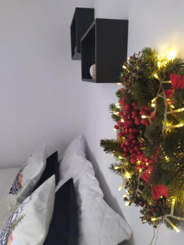 a christmas wreath on the wall next to a bed at Tiny Little House in Athens