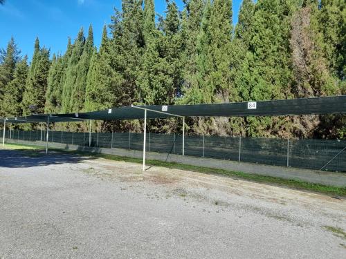 a tent in front of a fence with trees at Ibiscus Beach Village in Follonica
