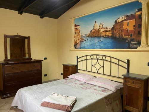ein Schlafzimmer mit einem Bett mit einem großen Gemälde an der Wand in der Unterkunft B & B Casal Pereto in Valmontone