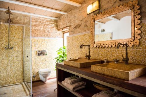 a bathroom with two sinks and a mirror at Elegant Restored Luxury 600 Year Old Farmhouse I Las Chumberas I 6 Bedrooms I Stunning Views I Santa Gertrudis in Santa Gertrudis de Fruitera