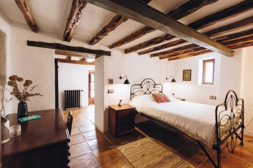 Schlafzimmer mit einem Bett und Holzboden in der Unterkunft Elegant Restored Luxury 600 year old Farmhouse Las Chumberas 6 Bedrooms Stunning Views Santa Gertrudis in Santa Gertrudis