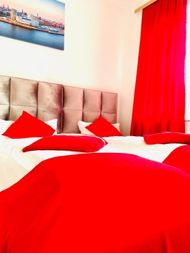 two beds with red blankets and pillows in a bedroom at Hotel STORY Hamburg in Hamburg