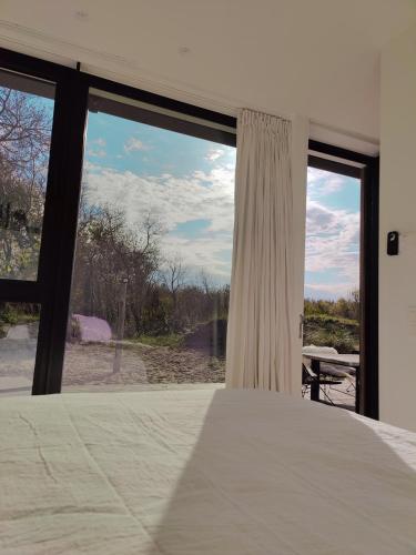 a bedroom with a bed and a large window at La Naturale Garden zeezicht in Zeebrugge