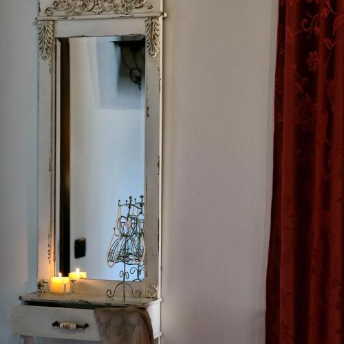 a mirror on a wall with candles on a table at Piana la Gatta in Cusano Mutri