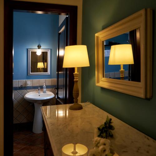 a bathroom with a sink and a table with a lamp at Piana la Gatta in Cusano Mutri