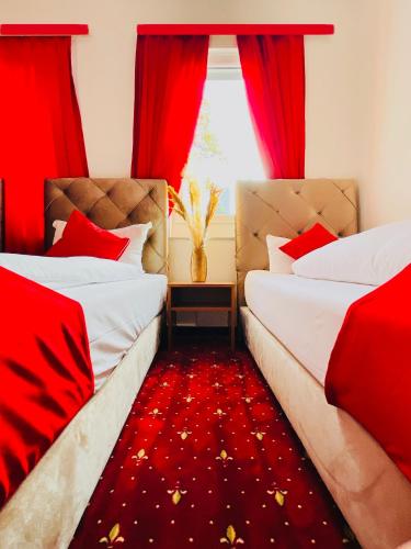 two beds in a room with red curtains and a red carpet at Hotel STORY Hamburg in Hamburg