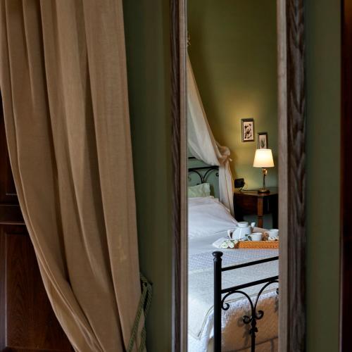 a mirror in a bedroom with a bed and a lamp at Piana la Gatta in Cusano Mutri