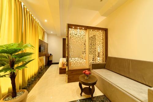 uma sala de estar com um sofá e um vaso de plantas em Hotel Avalon Palms Agra em Agra