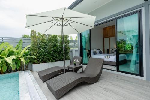 a patio with a chair and an umbrella and a bedroom at Bonita Pool Villa in Buriram