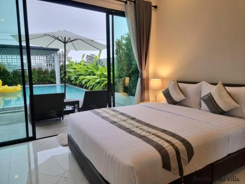 een slaapkamer met een bed en een balkon met een zwembad bij Bonita Pool Villa in Buriram