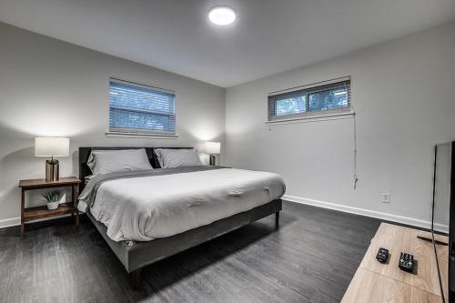 a bedroom with a large bed and two windows at Sweet Retreat in North Dallas in Dallas