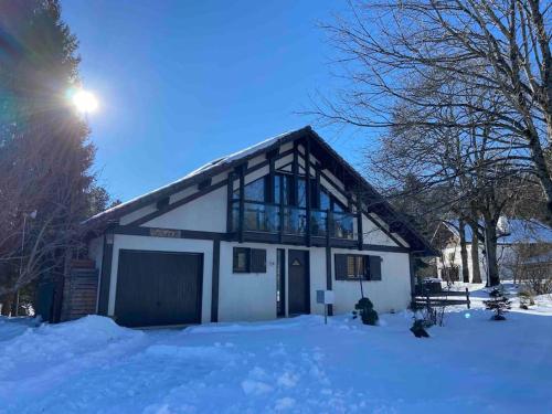 a house with a garage in the snow at Unique Sustainabel Lodge in the Swiss Jura Mountains in Neuchâtel