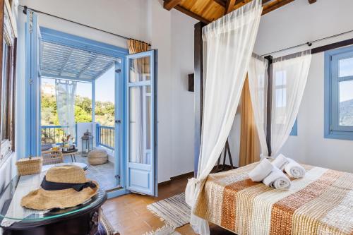 a bedroom with two beds and a door to a balcony at villa Avaton near Skopelos town in Skopelos Town