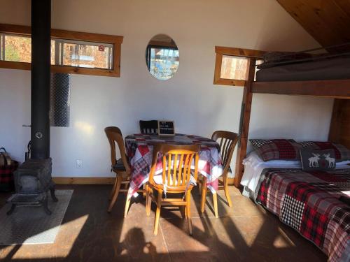 a room with two bunk beds and a table and chairs at Les Cabines Nordik 2.0 in Shawinigan