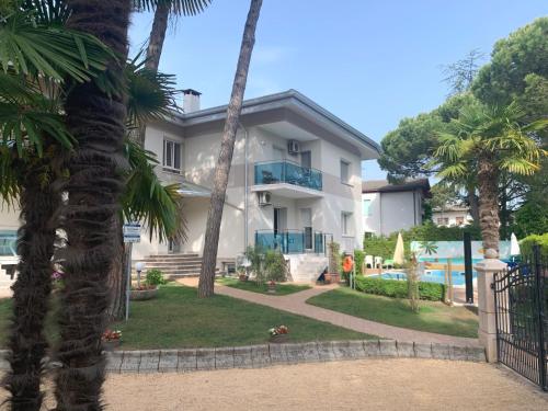 una casa con palmeras y piscina en Villa Elisabeth, en Lignano Sabbiadoro