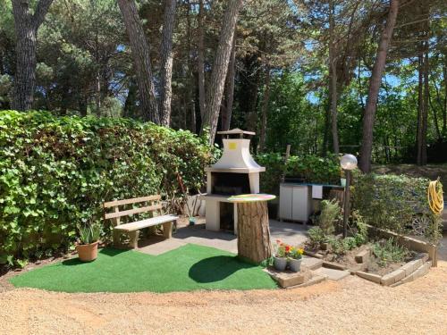 un jardín con un banco y un alimentador de aves en Villa Elisabeth, en Lignano Sabbiadoro