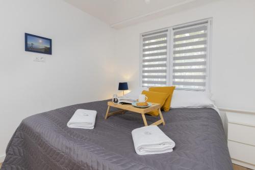 a bedroom with a bed with a table and a window at Dedala Apartment 300m to the Beach by Renters in Gdynia