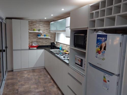 cocina con armarios blancos y nevera en CASABLANCA APARTAMENTOS en San Roque