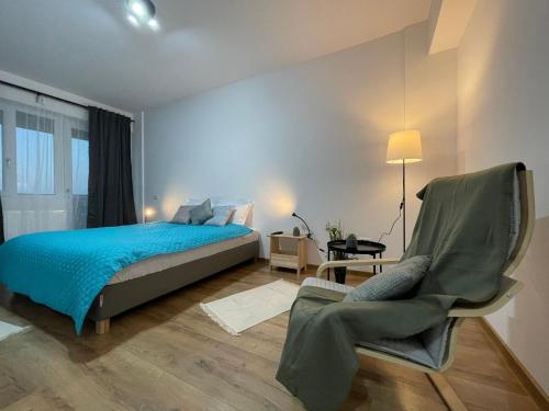 1 dormitorio con 1 cama y 1 silla en Luxury Q Residence near Palas Mall en Iaşi