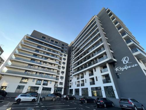 un gran edificio de apartamentos con coches aparcados en un aparcamiento en Luxury Q Residence near Palas Mall, en Iaşi