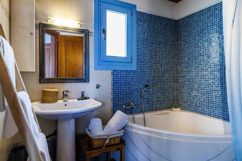 a bathroom with a white tub and a sink and a bath tub at villa Avaton near Skopelos town in Skopelos Town