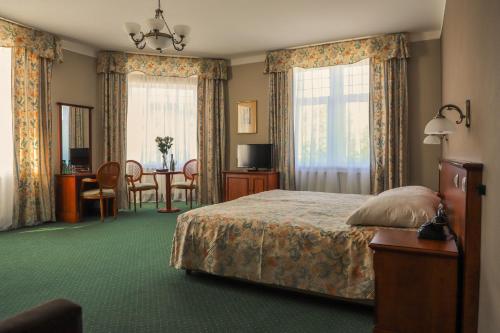 une chambre d'hôtel avec un lit et une salle à manger dans l'établissement Union Hotel Prague, à Prague