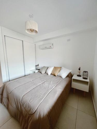 a bedroom with a large bed in a white room at KIRA HAUS, North Green in Villa Allende