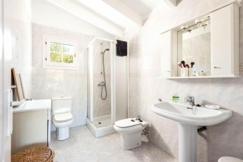 a white bathroom with a sink and a toilet at Villa Hércules 115 Binidali in Cap d'en Font