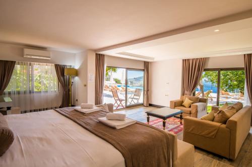 a large bedroom with a large bed and a living room at The Mediteran Hotel in Kalkan