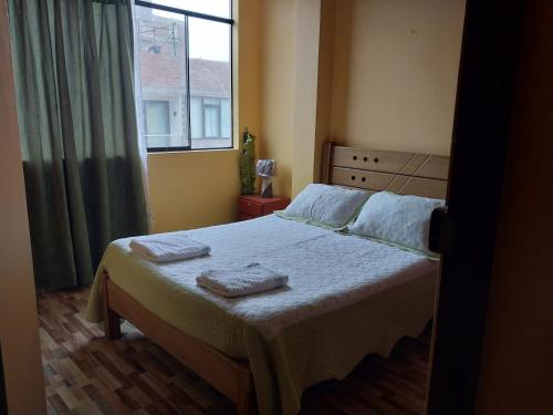 una camera da letto con un letto e due asciugamani di Huayqui a Lima