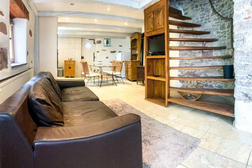 - un salon avec un canapé en cuir et un escalier dans l'établissement Le patio du Château de Thanvillé, à Thanvillé